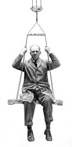 man suspended in a swing from the bar handle of a piece of ‘Phoenix